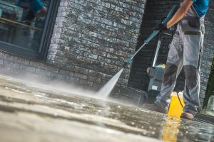 Person Power washing a sidewalk